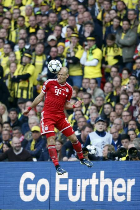 De Bedummer kopt de bal met op de achtergrond de in het geel gehulde fans van Borussia (Foto: Pro Shots)