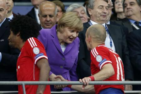 Angela Merkel feliciteert Robben bij de prijsuitreiking op de eretribune van het Wembley Stadium (Foto: Pro Shots)