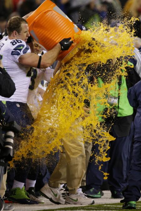 Volgens goede traditie kreeg de winnende coach na de Super Bowl een flinke plens Gatorade in zijn nek. Pete Carroll kreeg een flinke bak van het gele goedje over zich heen. Wat zou een geschikt onderschrift zijn bij deze foto? (Foto: Pro Shots)