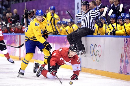 De arbiter zoekt een veilig heenkomen tijdens de ijshockeyfinale tussen Zweden en Canada (PRO SHOTS/Bildbyran)