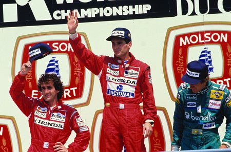 Bij McLaren werd hij teamgenoot van Alain Prost (links naast Senna op het podium). De jaren die volgenden zouden in het teken staan van de hevige rivaliteit tussen de twee. Die tweestrijd zette zich voort toen Prost in 1990 naar Ferrari vertrok (WikiCommons/Angelo Orsi)