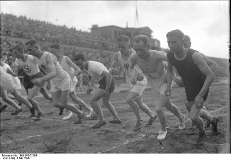 Nurmi - met het kruisje bij zijn voeten - op weg naar het wereldrecord op de 3000 meter. De wedstrijd vond plaats in het Deutsches Stadion in Berlijn, waar in 1916 de Spelen gehouden zouden moeten worden (Foto: WikiCommons/BArchBot)