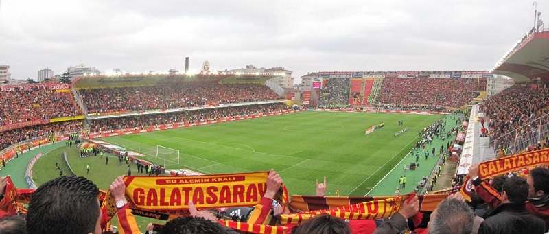 In 1936 kreeg Galatasaray het recht om een stadion te bouwen op een stuk land wat het van overheid huurde. De club kreeg de beschikking over het land voor een symbolisch bedrag van 1 lira per jaar. In ruil daarvoor verplichte de club zich tot het bouwen van het stadion. Door diverse omstandigheden, zoals het uitbreken van de Tweede Wereldoorlog, vlotte de bouw echter niet. Ook bezat de club uiteindelijk niet de financiële middelen om het gewenste stadion te bouwen in die tijd. In 1959 begon dan toch eindelijk de bouw van het Ali Sami Yen Stadion. Vijf jaar later, in 1964, werd het stadion geopend met een wedstrijd tussen Turkije en Bulgarije. (WikiCommons/QWL)