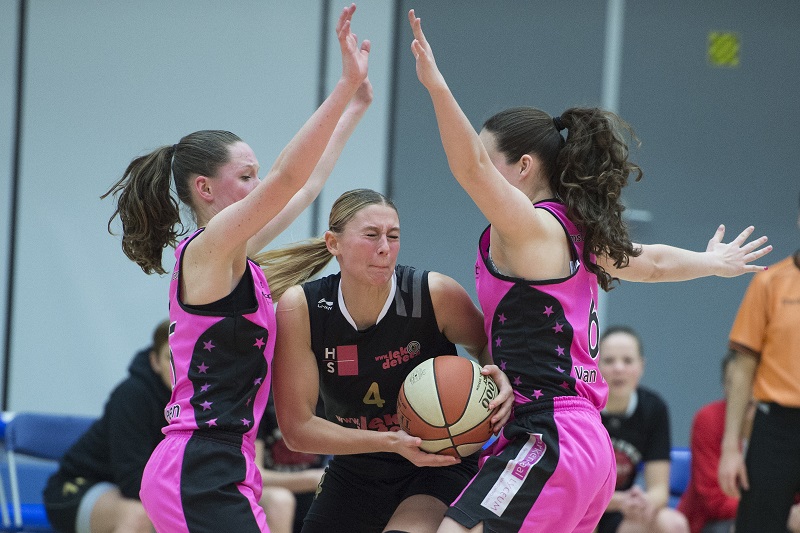 We kwamen deze foto tegen uit de Eredivisie damesbasketbal. Batouwe-speelster Gabrielle van den Bosch is hier in duel met CTO Amsterdam-speelsters Janiek van Veen en Anne van Vlijmen. Wat zou een goed onderschrift zijn bij deze foto? (PRO SHOTS/Jasper Ruhe)