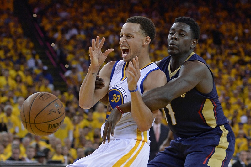 Golden State Warriors-speler Stephen Curry is een stevig duel met New Orleans Pelicans-speler Jrue Holiday verwikkeld. Wat zou een goed onderschrift zijn bij deze foto? (PRO SHOTS/Zuma Sports Wire)