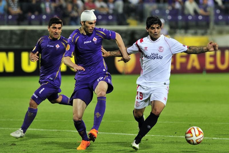 Éver Banega (Sevilla) met twee tegenstanders van Fiorentina. (PRO SHOTS/Marca)