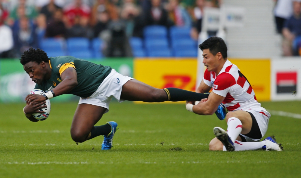 Het WK Rugby is in volle gang en FOK! doet daar volop verslag van. Het mooie van rugby is ook dat het prachtige foto's oplevert, zoals ook deze. De Zuid-Afrikaan Lwazi Mvovo wordt bij zijn enkel gegrepen door de Japanner Akihito Yamada, wat zou een goed onderschrift zijn voor deze foto? (Pro Shots/Action Images)