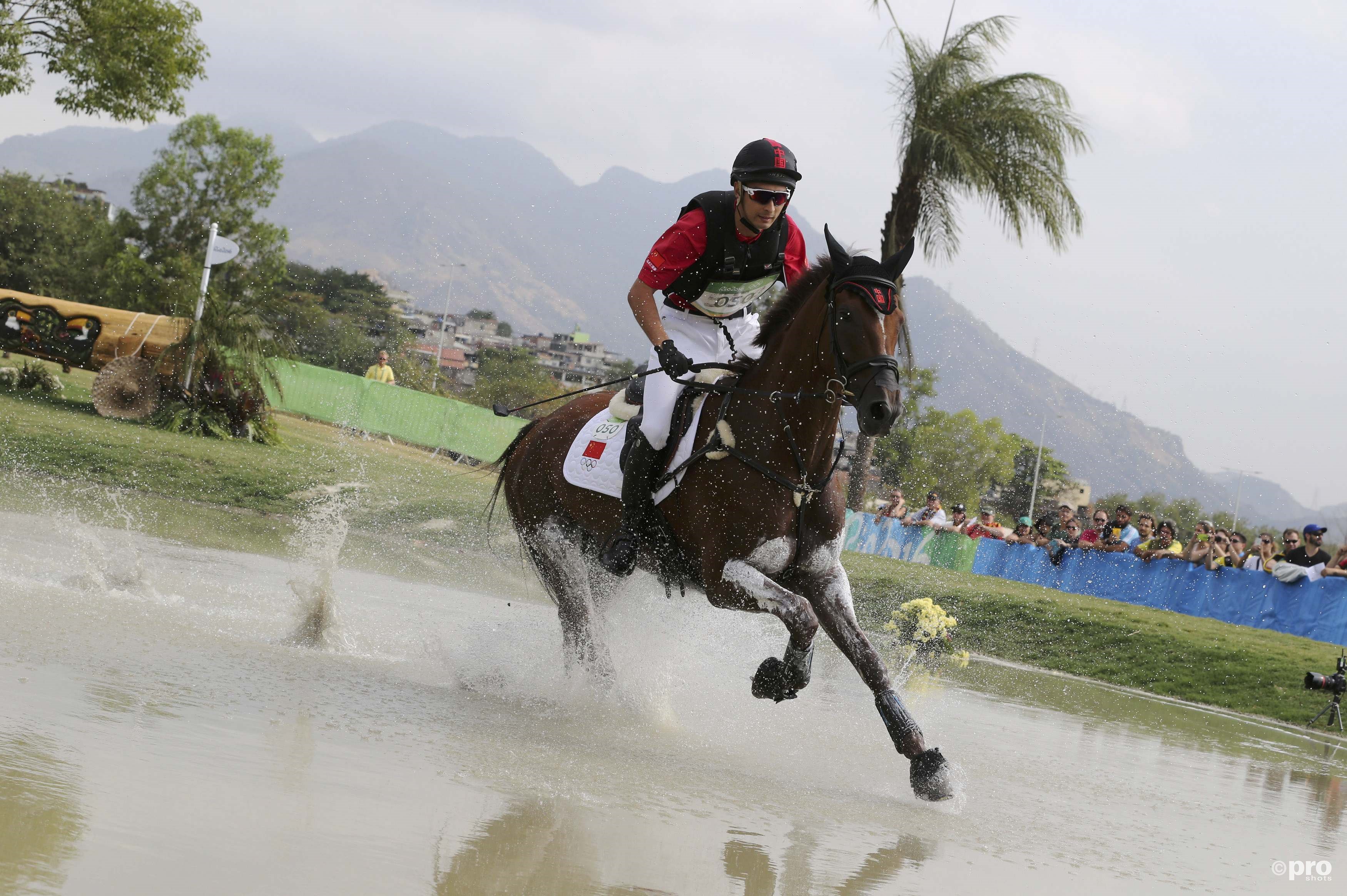 Alsof Alex Hua Tian met zijn paard over het water loopt tijdens het eventing (Pro Shots / Action Images)