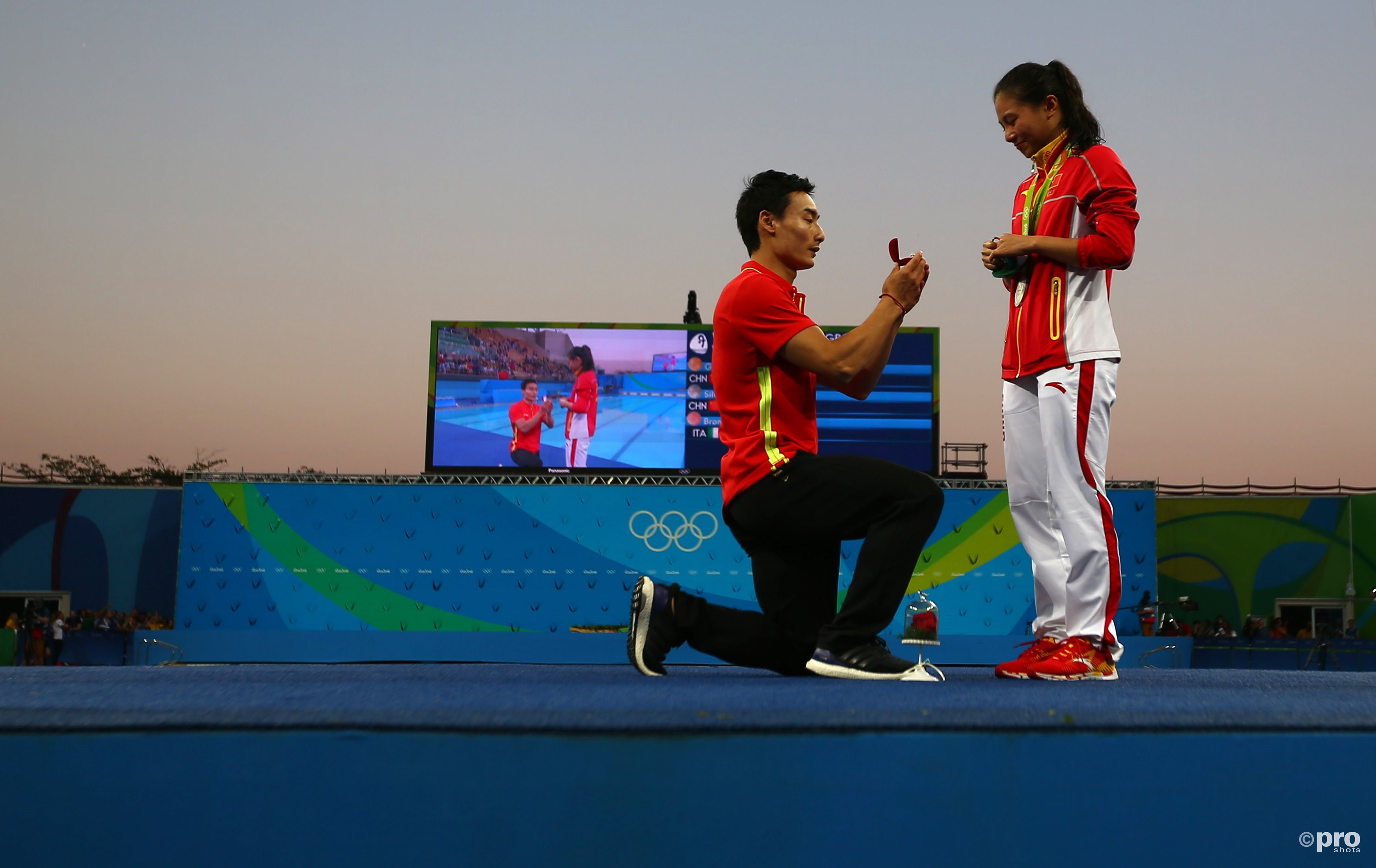 Qin Kai gaat op de knieeën voor zijn vriendin He Zi, die haar zilveren medaille net omgehangen heeft gekregen (PROSHOTS/Action Images)