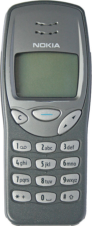 Eind jaren '90 vonden mobiele telefoons hun weg naar het grote publiek. De Nokia 3210 was één van de populairste telefoons van de tijd. Je kon het frontje wisselen en snake spelen, toffer werd het niet in die tijd. (WikiCommons/Discostu)