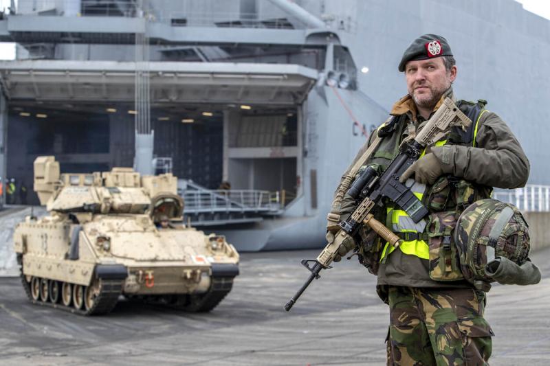 Archieffoto maart 2022 van een Bradley-pantservoertuig en een Nederlandse militair tijdens het verlenen van Host Nation Support (Afbeelding: Defensie)