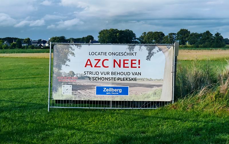 Protestbord tegen AZC in gemeente Deurne 2023 (@WikimediaCommons)