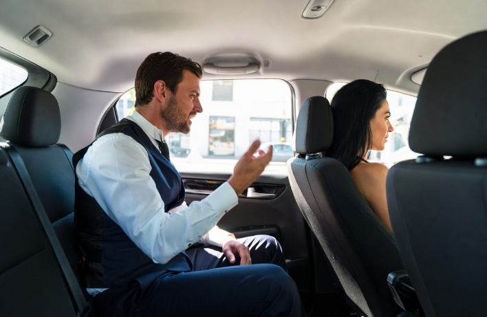 Man in pak op weg naar sollictatie in een taxi. Hij doet bozig naar de chauffeur.